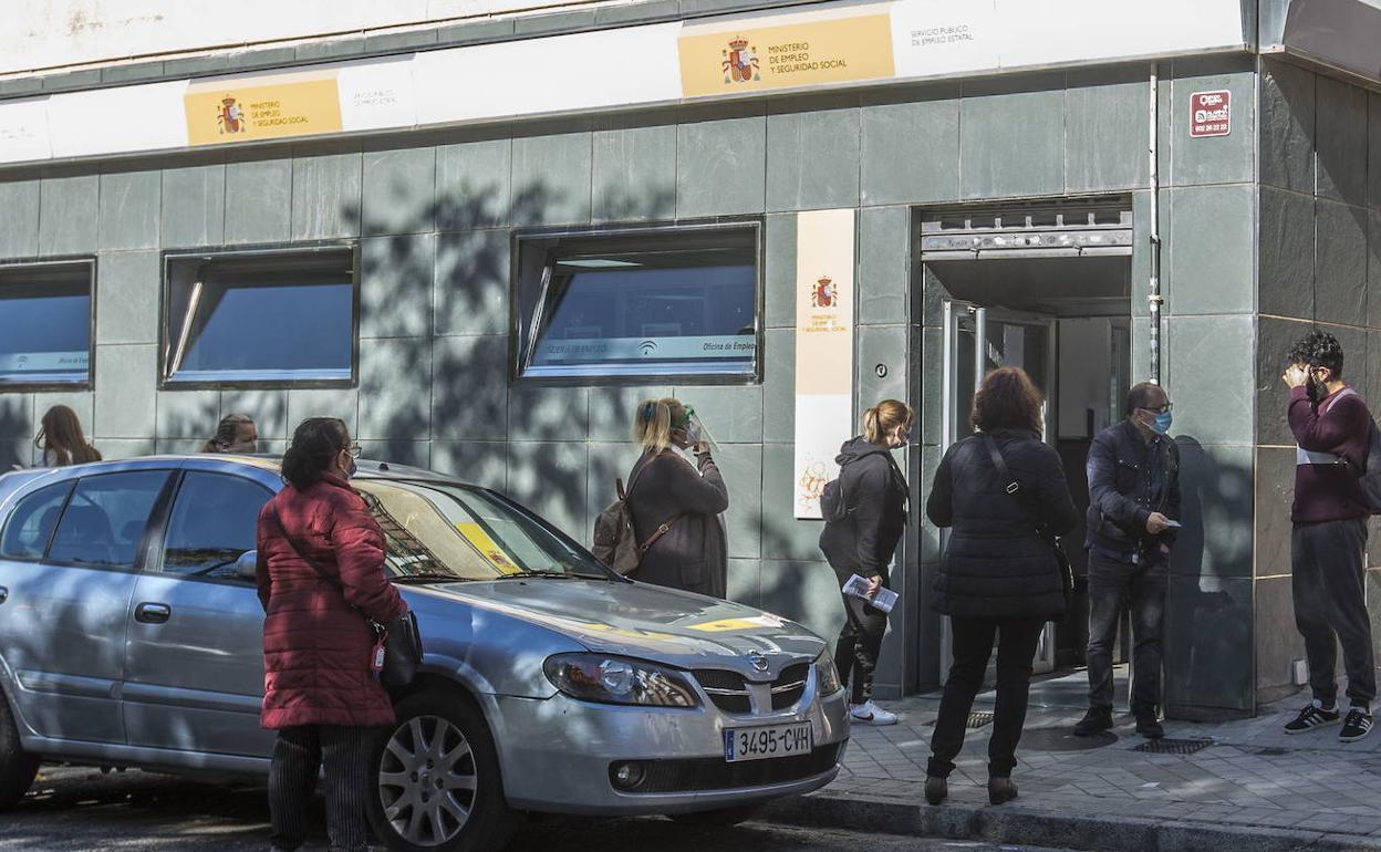 Un grupo de personas espera en la puerta de una oficina del Servicio Público de Empleo Estatal (SEPE) en la capital granadina. 