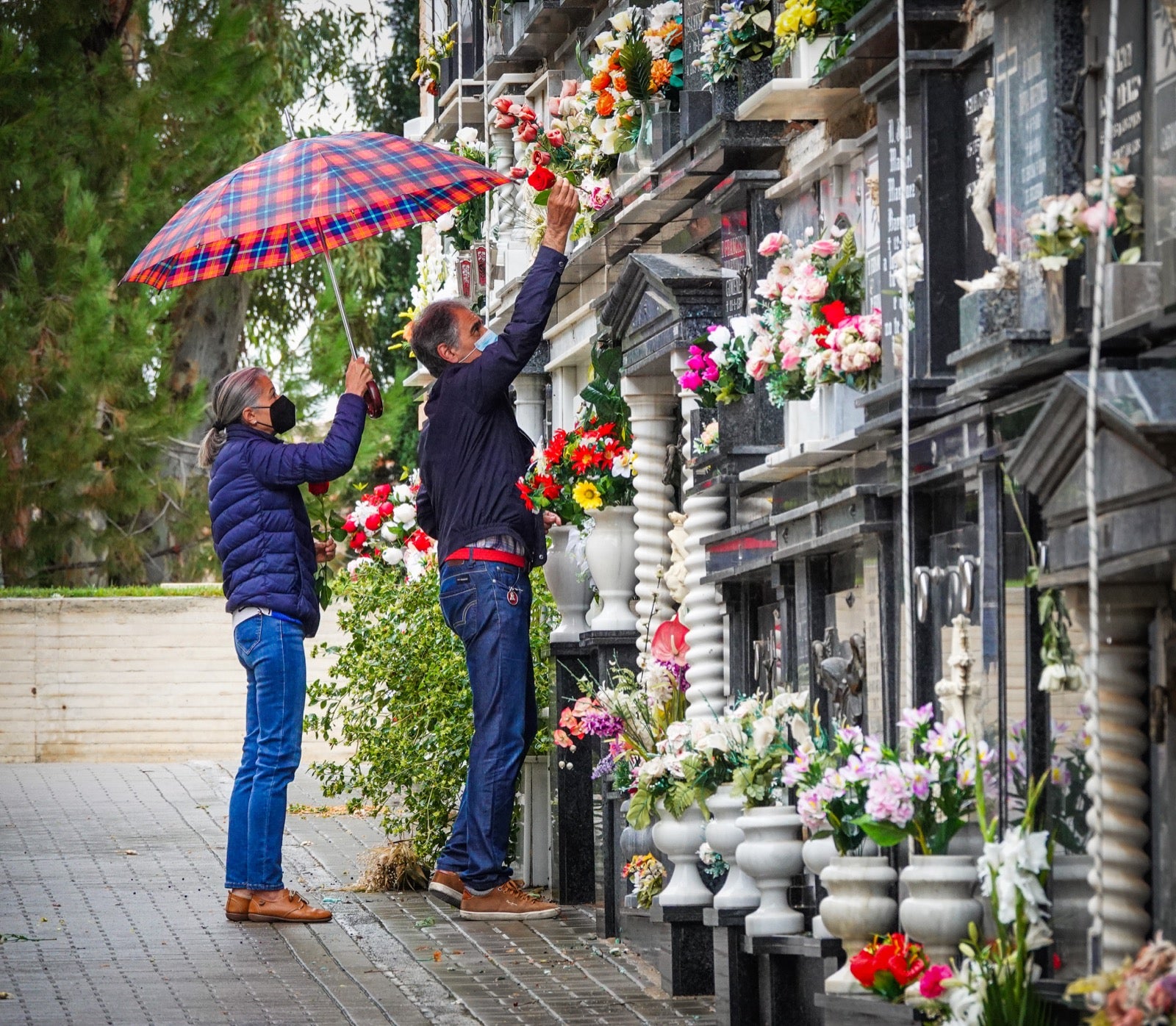Los granadinos acuden al cementerio con flores en el día de Todos los Santos.