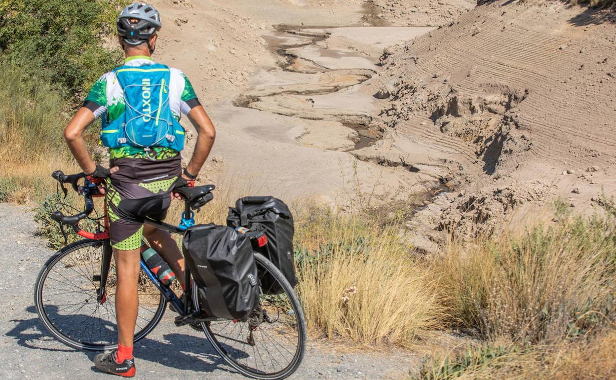 Un ciclista observa un camino de agua seco en el pantano de Quéntar el pasado 29 de septiembre. 