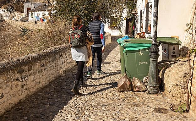 Imagen principal - Contenedores de basura en la Verea de Enmedio, solar sin adecentar y tapa de alcantarilla rota.