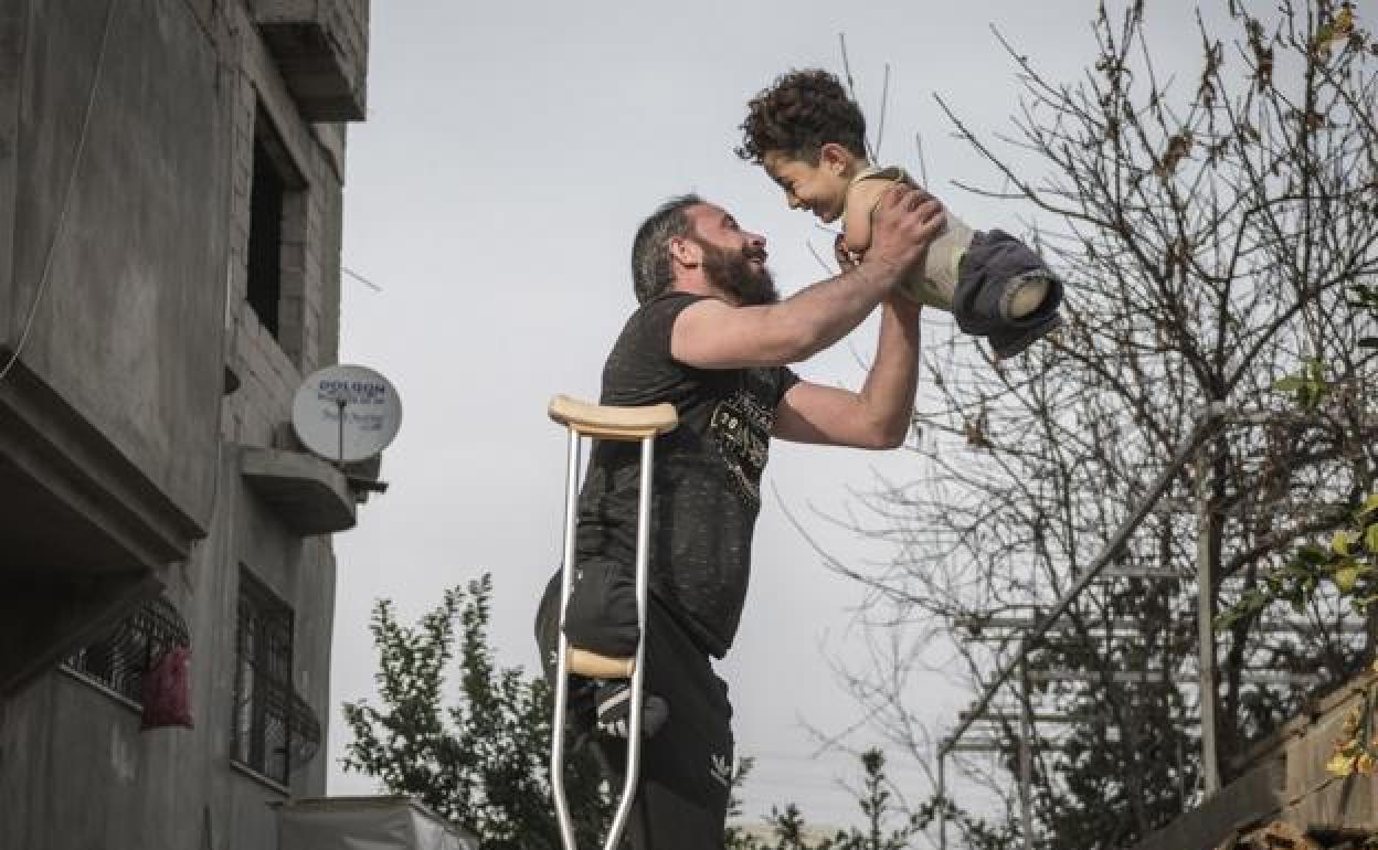 La fotografía retrata un momento de felicidad en el que un padre sin una pierna alza a su hijo de cinco años Mustafa, que debido a una enfermedad nació sin extremidades, y se ha convertido en viral en las redes sociales.