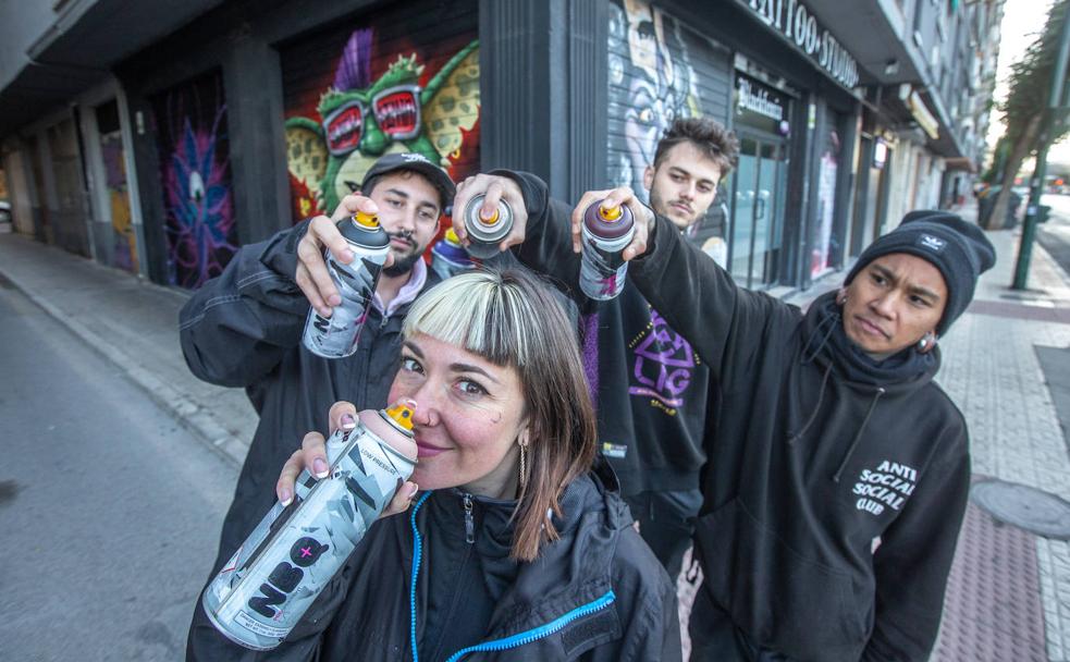 Flecha Uno, Dohe y Melcom 'pintan' a María Die ante persianas decoradas con grafitis de su autoría. 