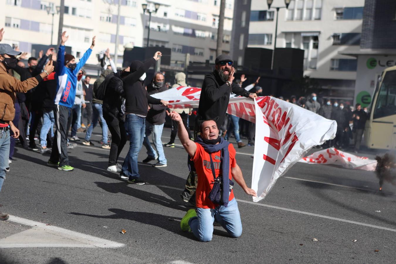 Un manifestante se arrodilla frente al cordón policial durante uno de los momentos de tensión en Cádiz