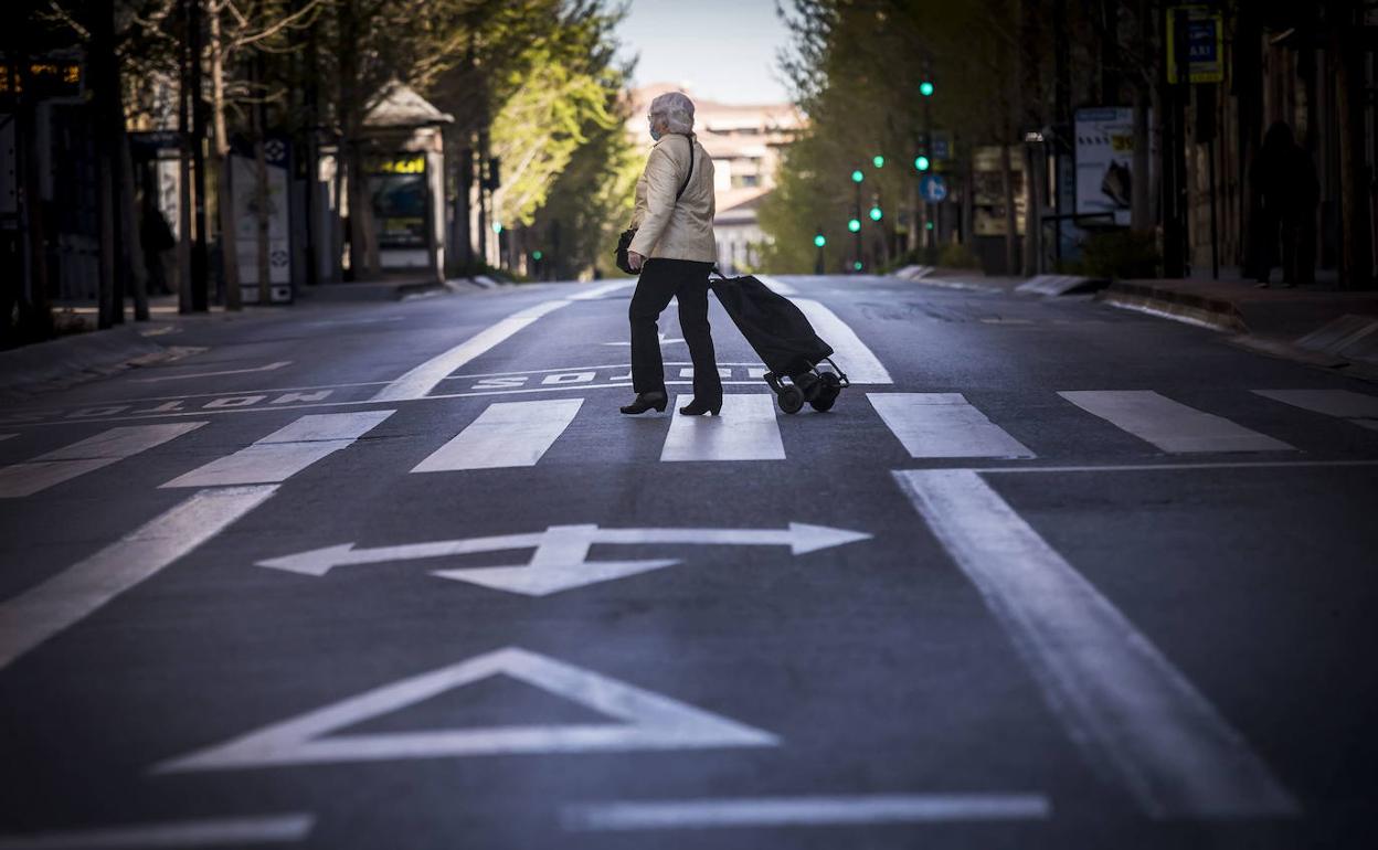Una señora cruza una Gran Vía sin vehículos.