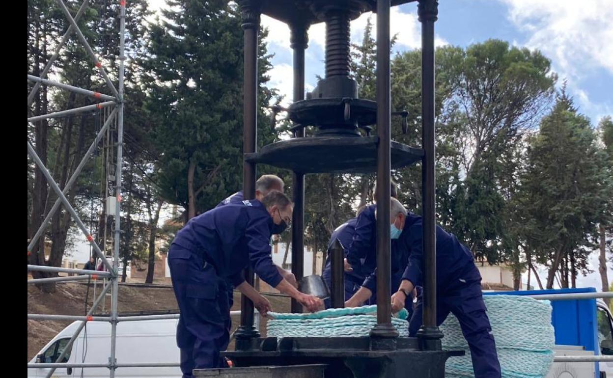 Agricultores durante la extracción del primer aceite de oliva de la cosecha con una prensa de husillo. 