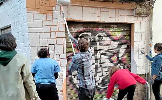 Imagen principal - Vecinos del Albaicín y estudiantes americanos se unen contra los grafitis del barrio