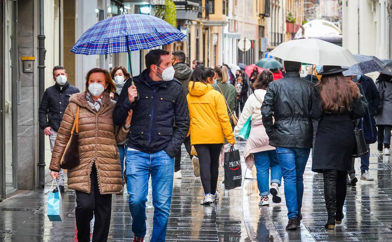 Un grupo de personas camina con mascarillas por una céntrica calle de la capital granadina. 