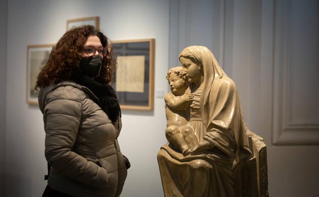 Imagen principal - Arriba, mujer junto a la escultura 'Virgen con Niño' de Diego de Aranda. Abajo, documentos de Ángel Barrios y foto donde aparecen Falle y Lorca. 