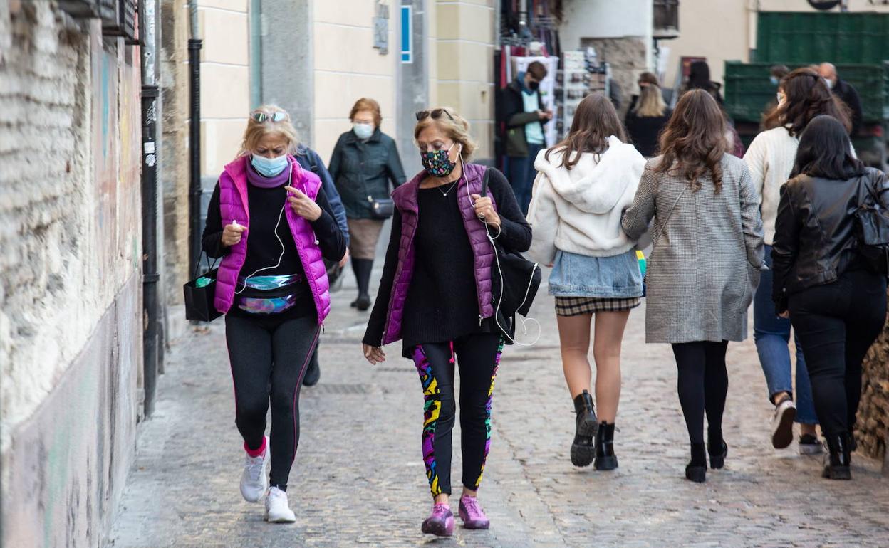 Gente con mascarilla por Granada. 