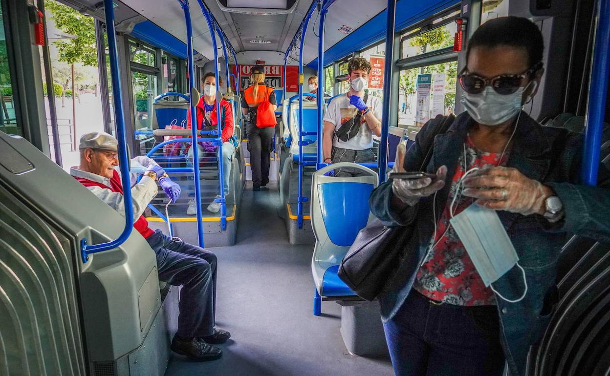 Usuarios de un autobús portando mascarillas