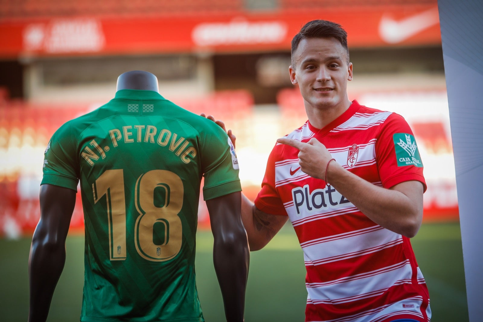 El centrocampista serbio del Granada posa de rojiblanco en su presentación oficial ante la afición.