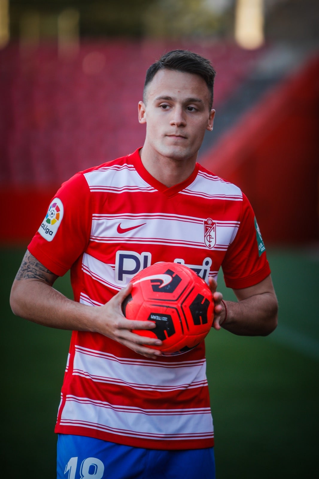 El centrocampista serbio del Granada posa de rojiblanco en su presentación oficial ante la afición.