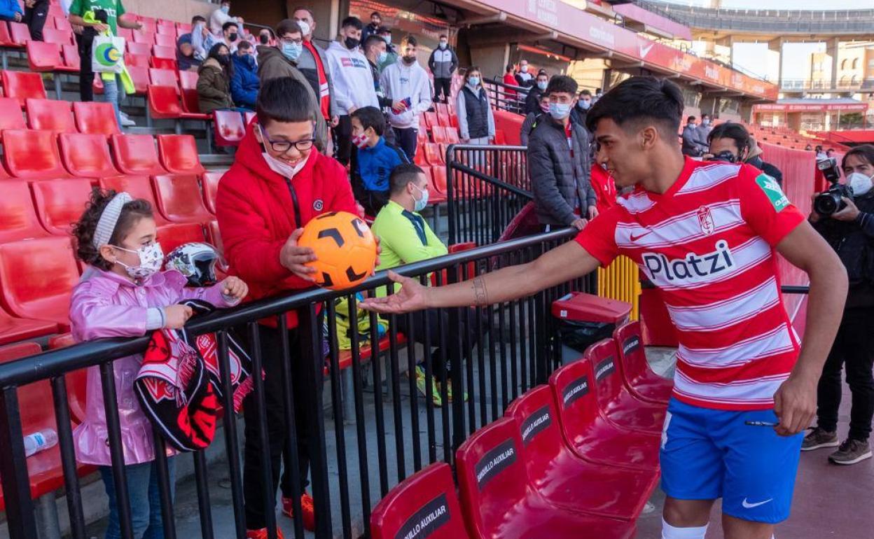 Matías Arezo entrega un balón a unos jóvenes aficionados del Granada en su presentación. 