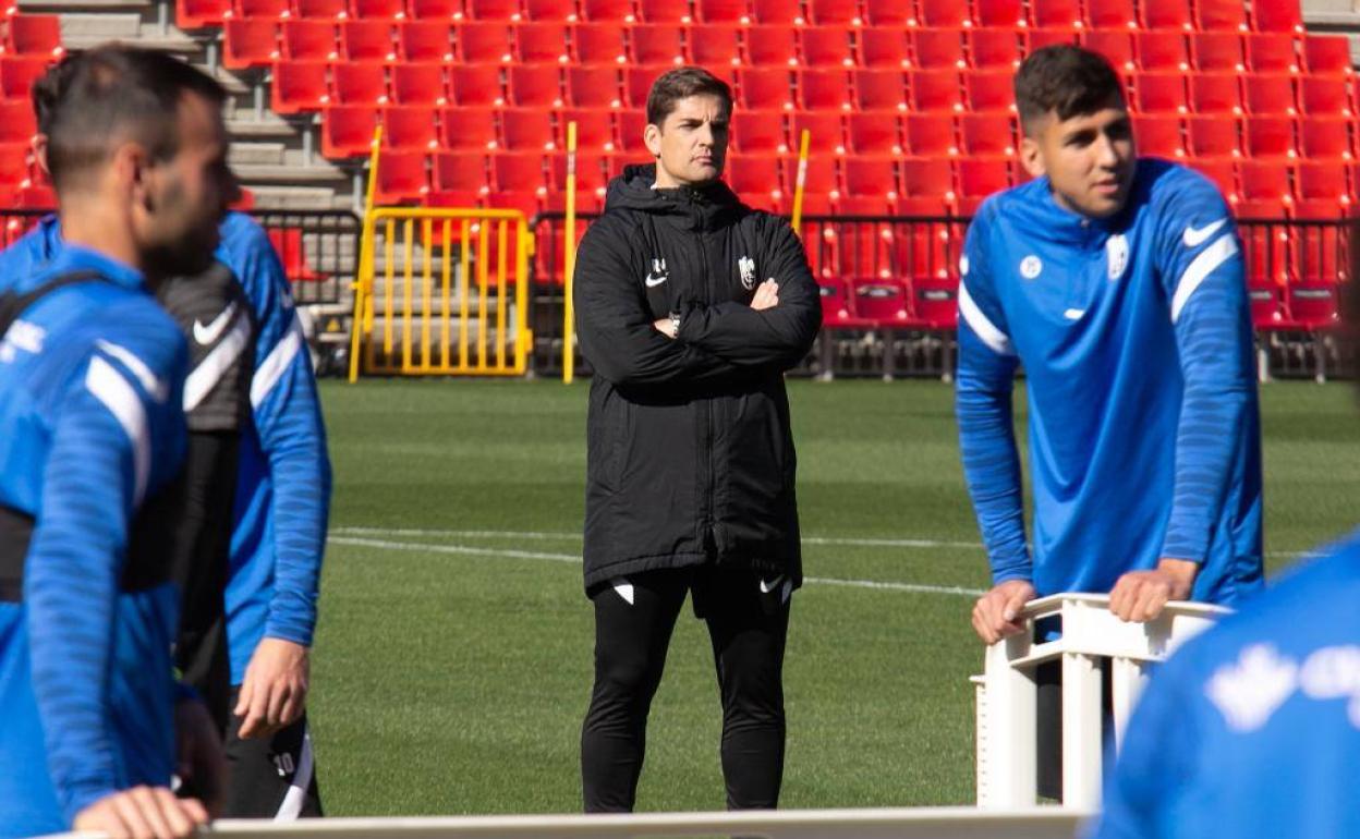 Robert Moreno contempla, serio y con brazos cruzados, a sus futbolistas en los juegos previos al último entrenamiento del equipo. 