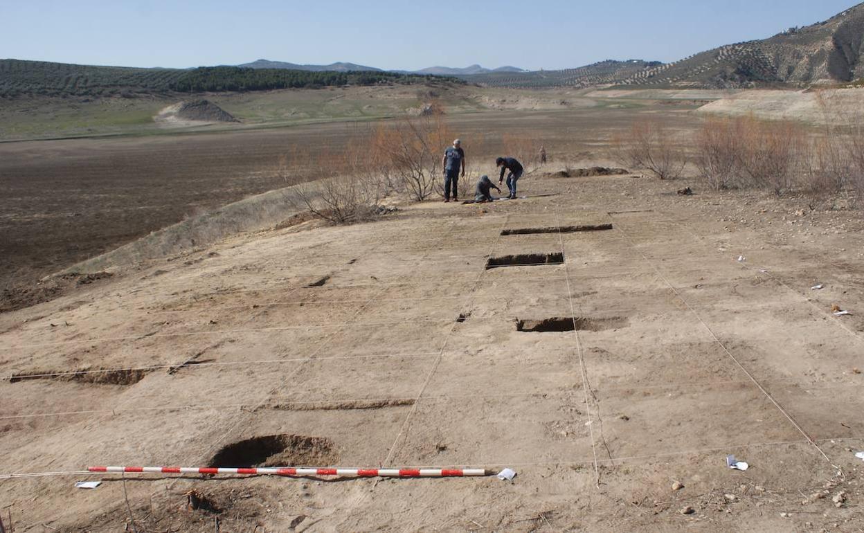 Excavando en el yacimiento neolítico hallado en la cola del pantano de Iznájar, que presenta este aspecto por la sequía. 