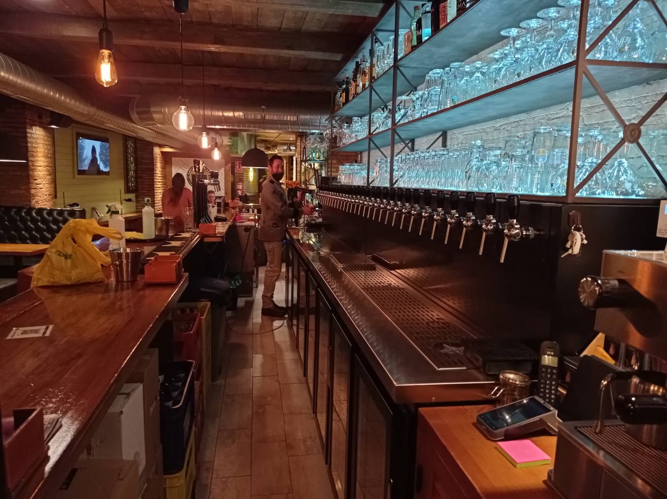 Ismael, propietario del Capitán Amargo, frente a su cañero con infinidad de cervezas