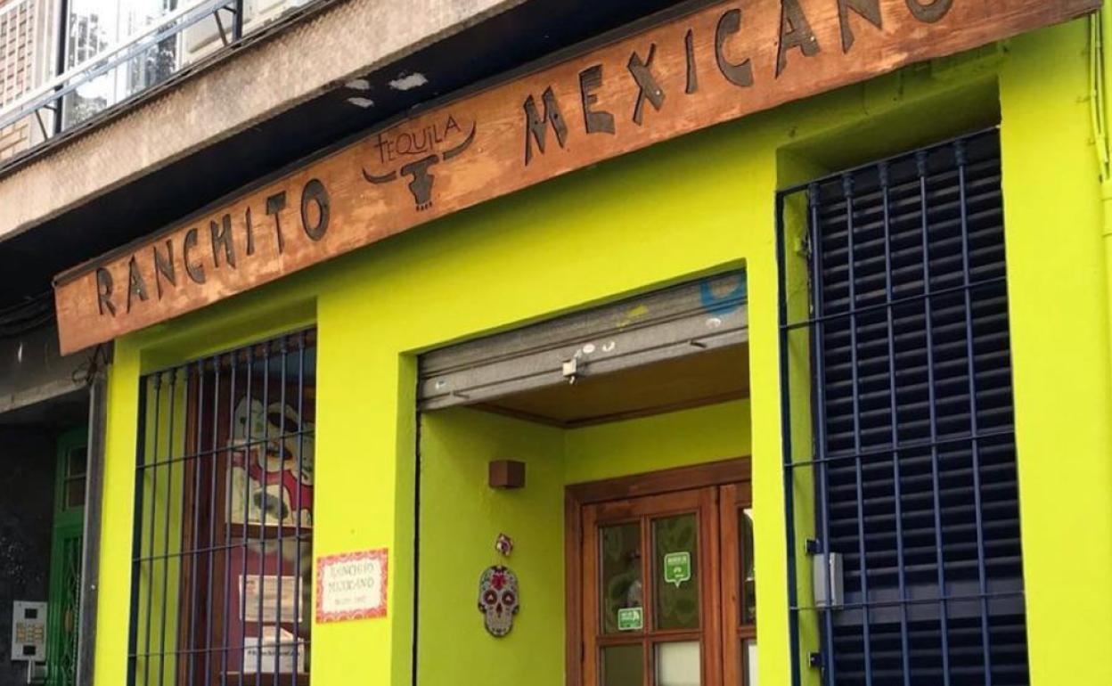 Fachada del restaurante con la calavera robada colgada junto a la puerta.