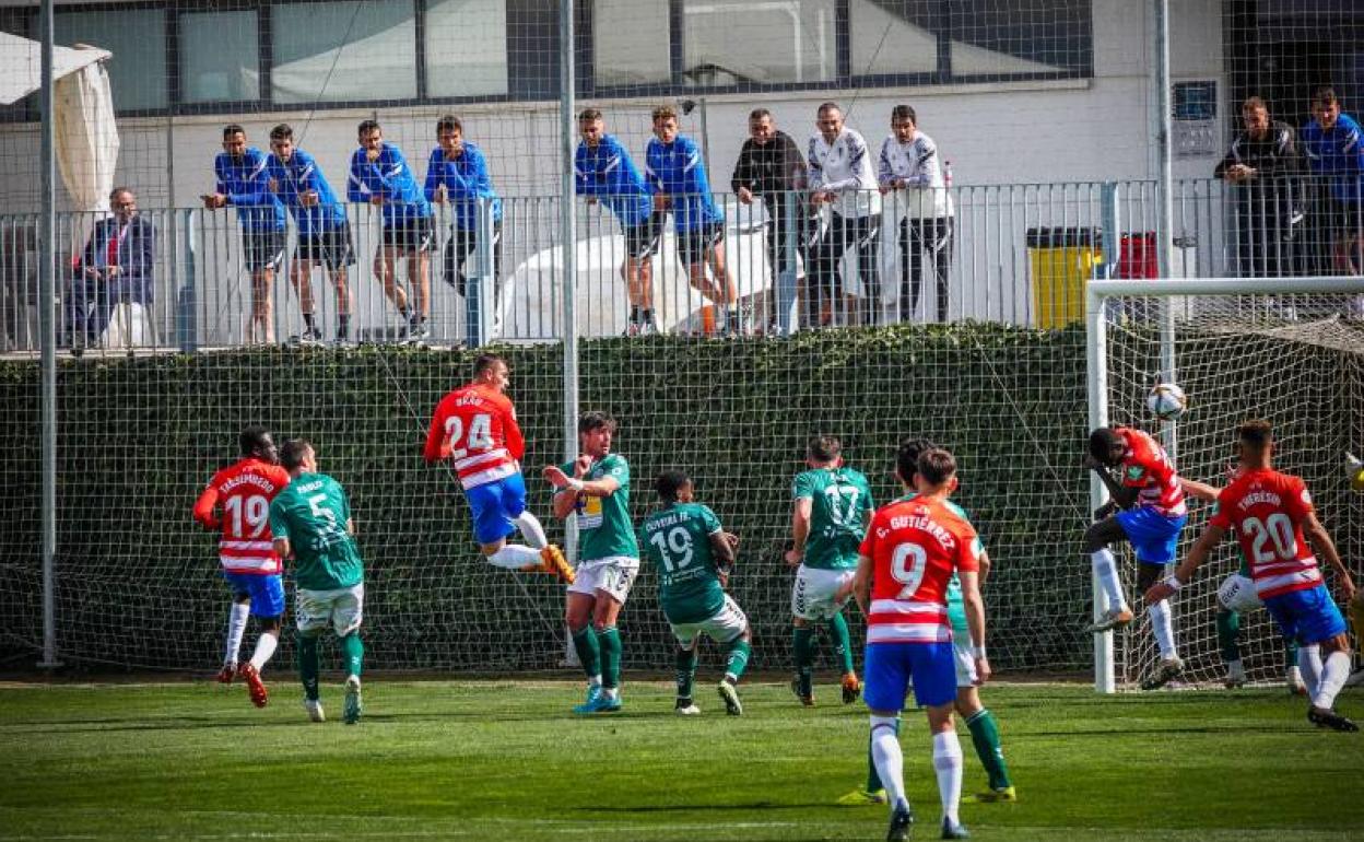 Brau, del filial, intenta un remate con varios futbolistas del primer equipo observando desde arriba. 