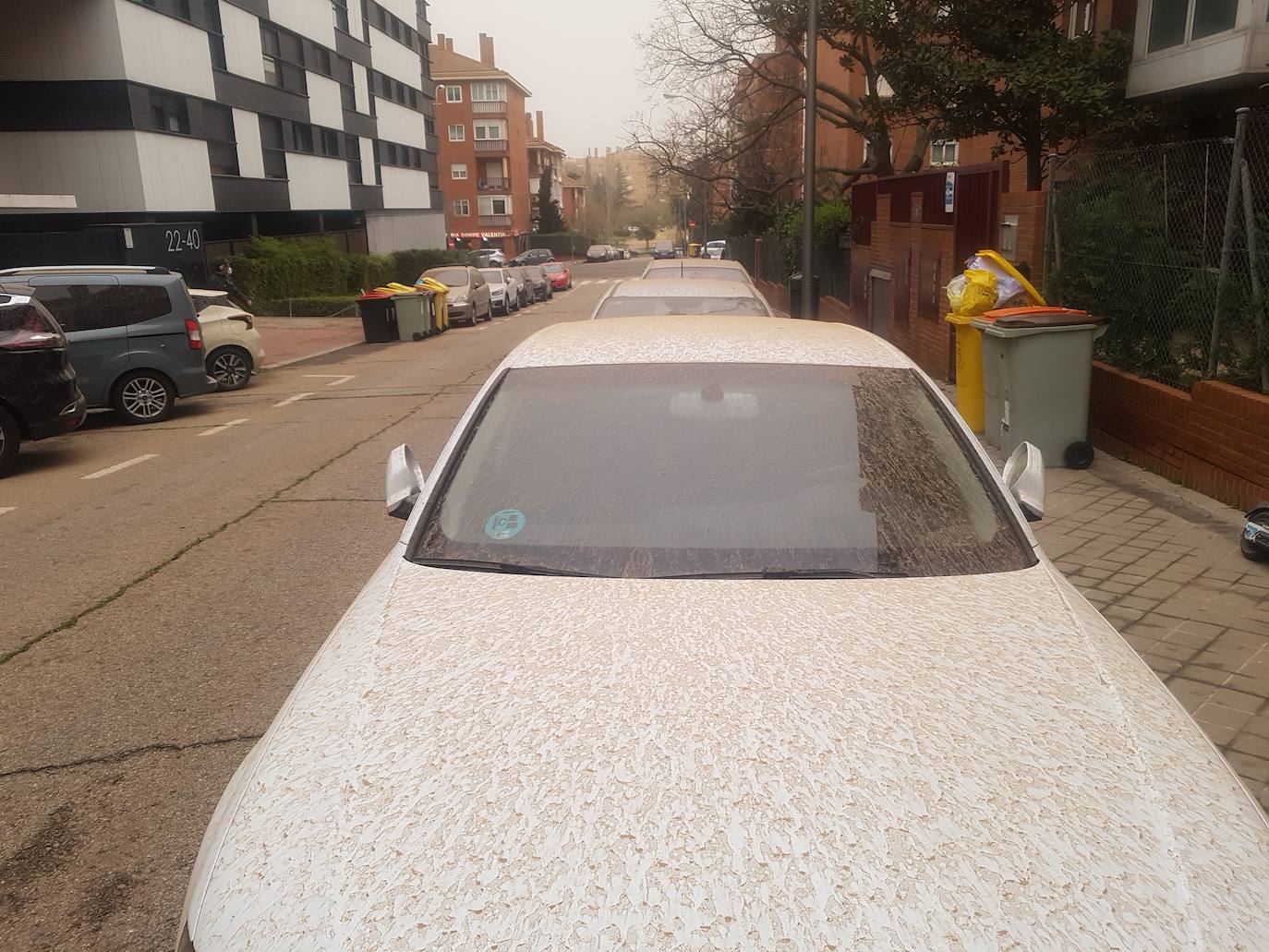 Un coche cubierto por una capa de polvo rojo procedente de la 'lluvia de barro' que ha caído en Madrid esta madrugada.