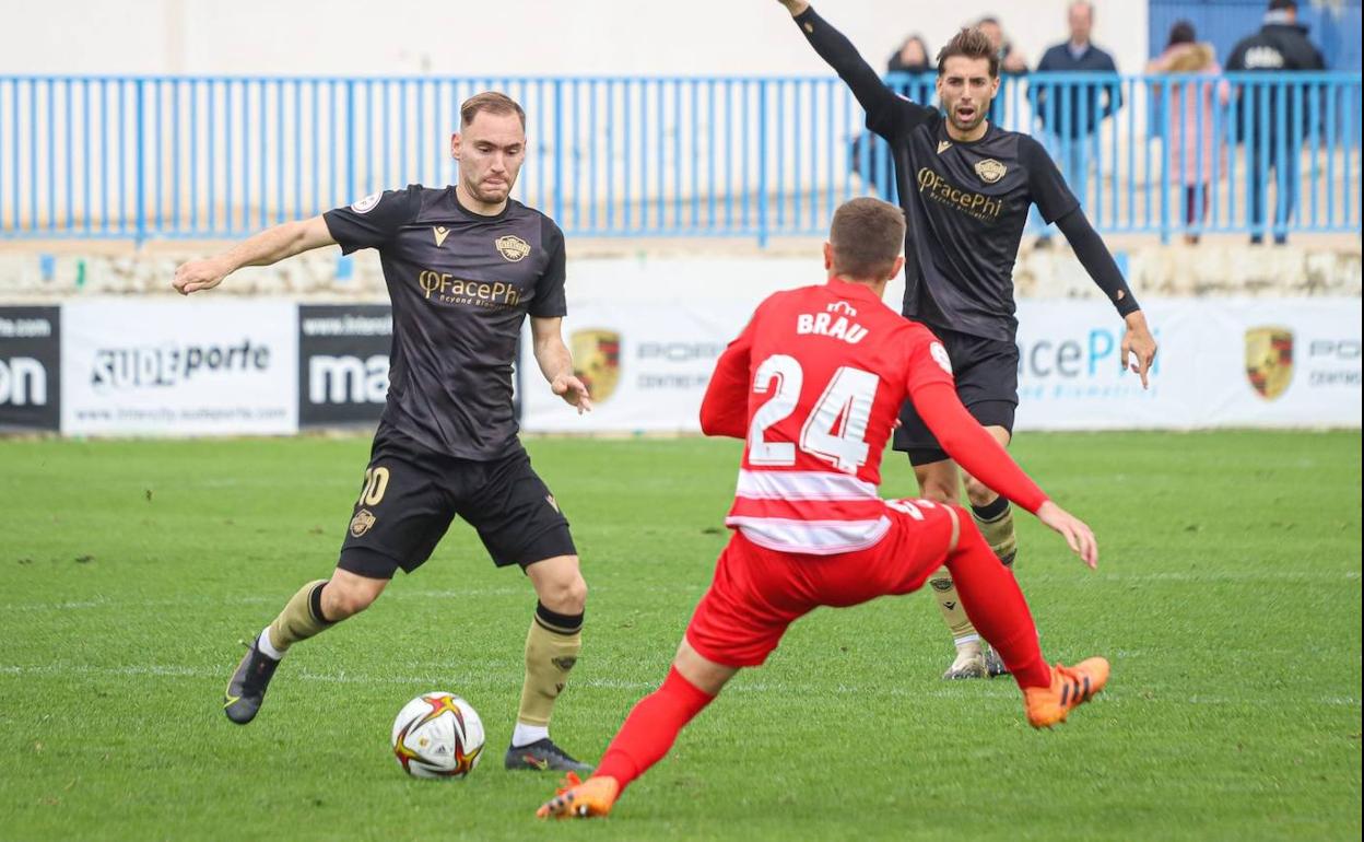 El rojiblanco Brau intenta impedir una jugada de ataque conducida por Cristian. 