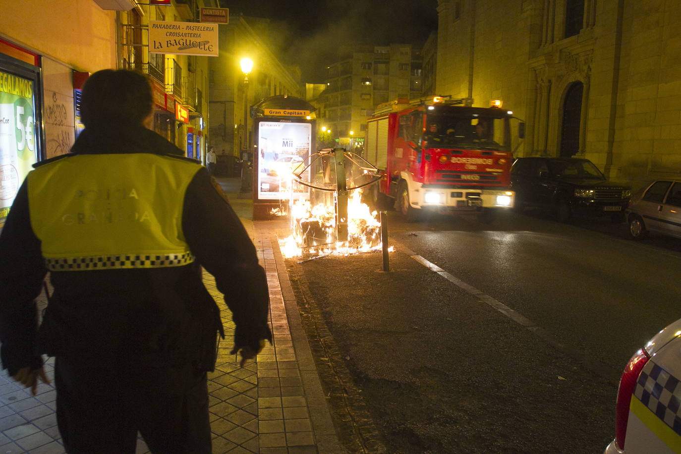 Un contenedor de basura arde en un calle de Granada.