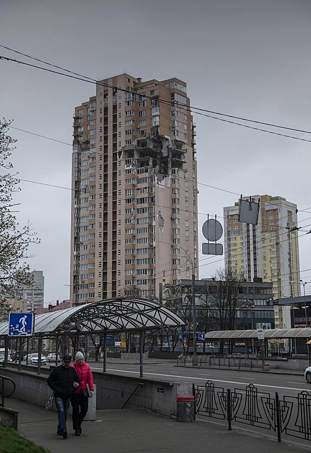 Viandantes, delante de edificio atacado en Kiev. 