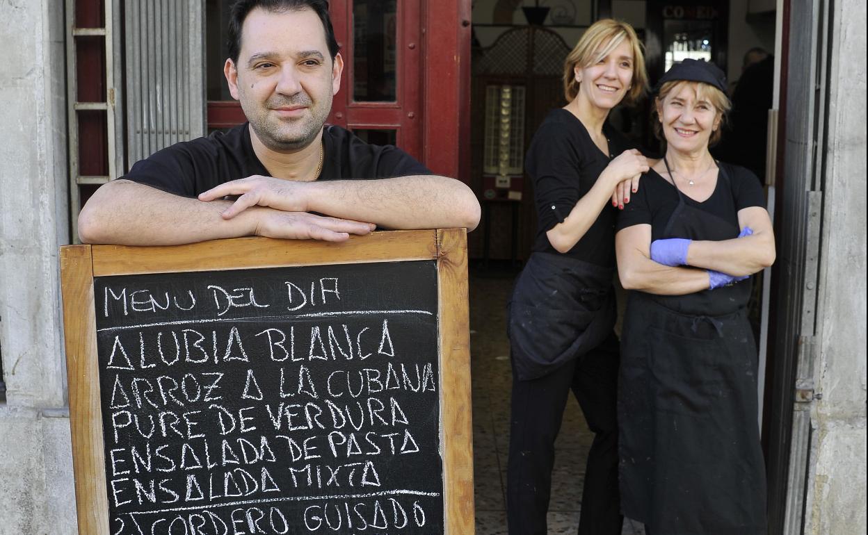 Los empleados de un restaurante muestran el menú del día.