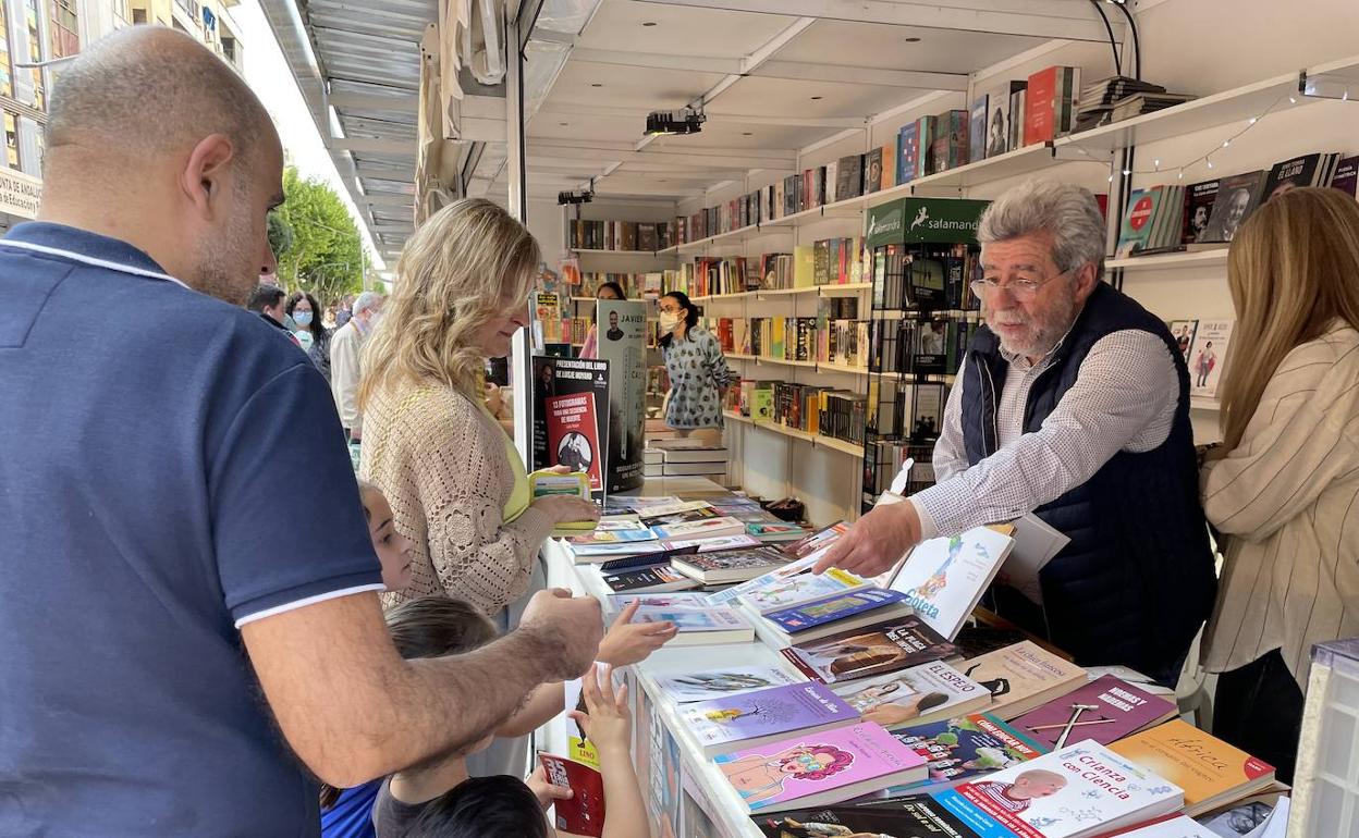 Pedro Molino atiende a una familia en la Feria del Libro.