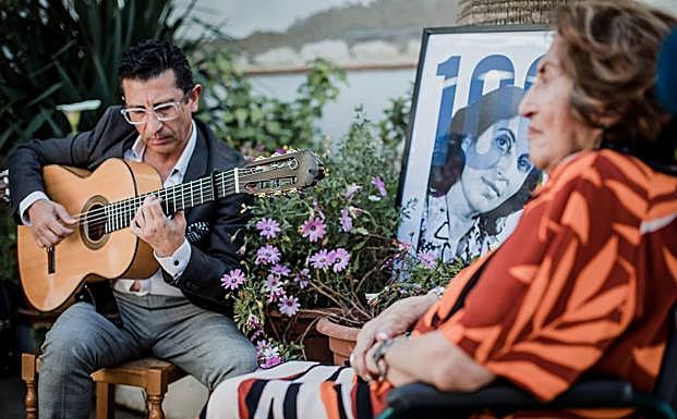 Miguel Ángel Corral toca la guitarra durante la celebración de los cien años de su progenitora. 