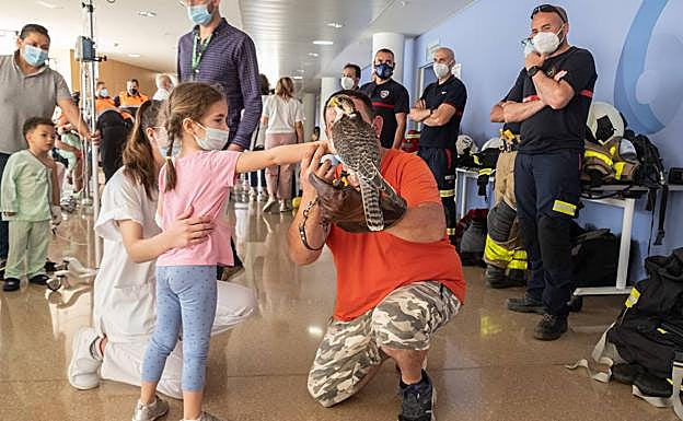 Rafa, halconero del aeropuerto, junto a una niña y una sanitaria.