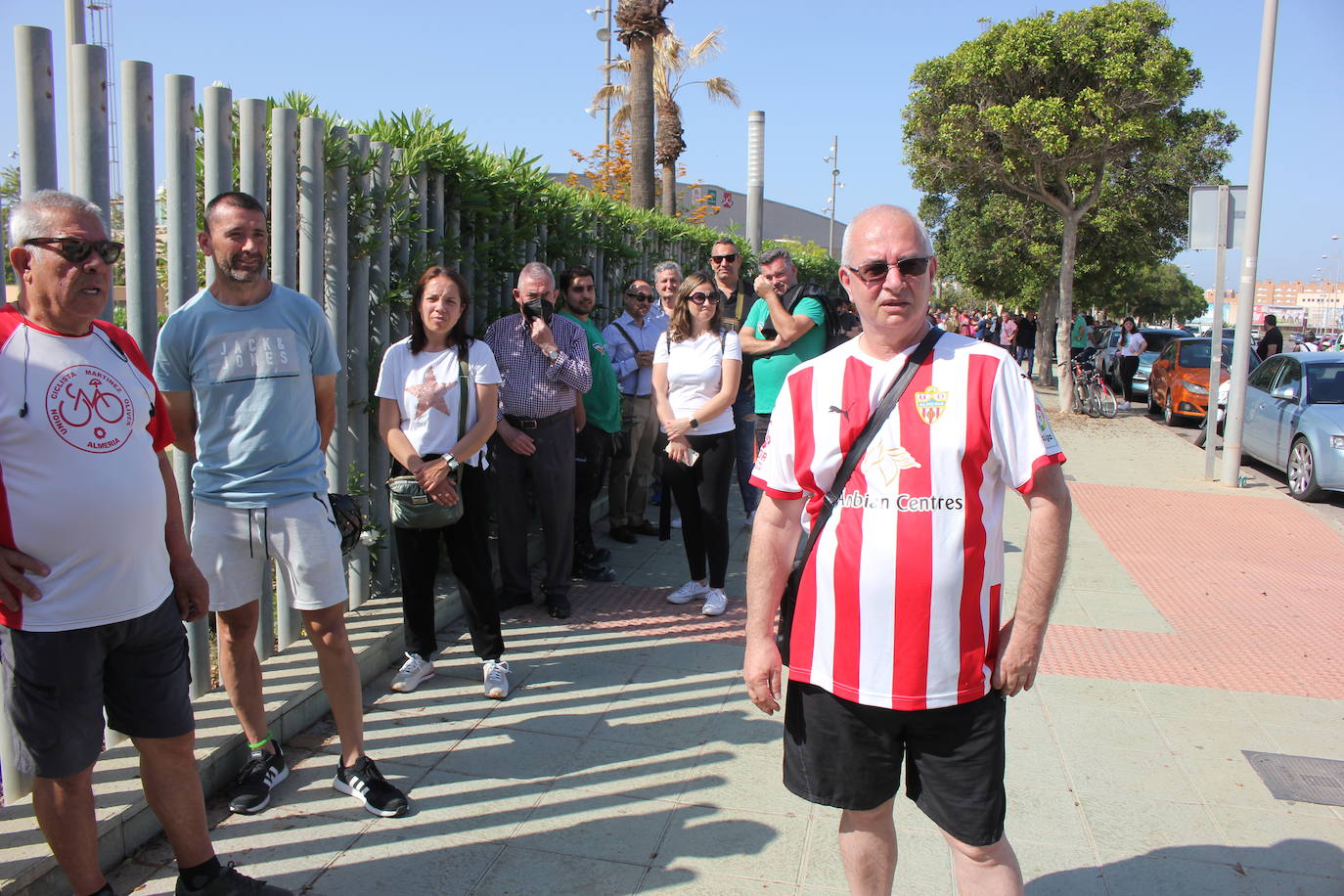 Imagen principal - Un aficionado con su camiseta (arriba); varios seguidores, tras pasar el primer filtro, a las puertas de la sede (abajo izda.), la cola 