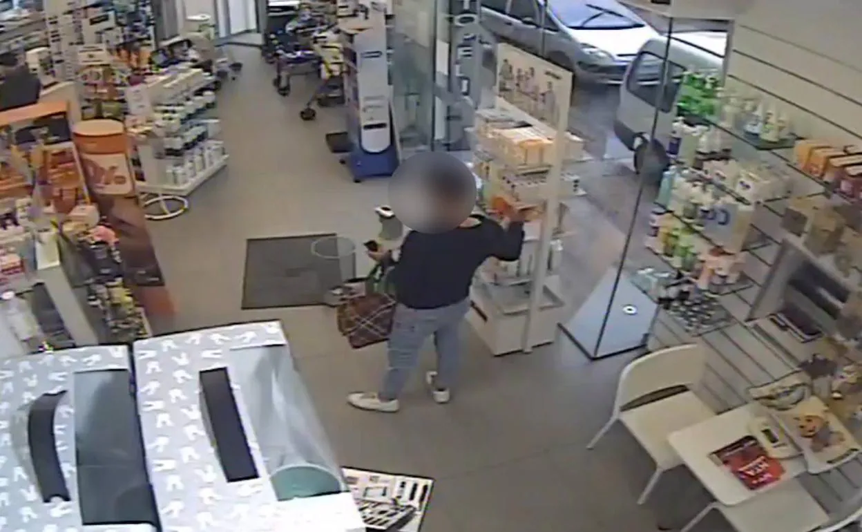 El joven detenido cargando la bolsa en una farmacia.