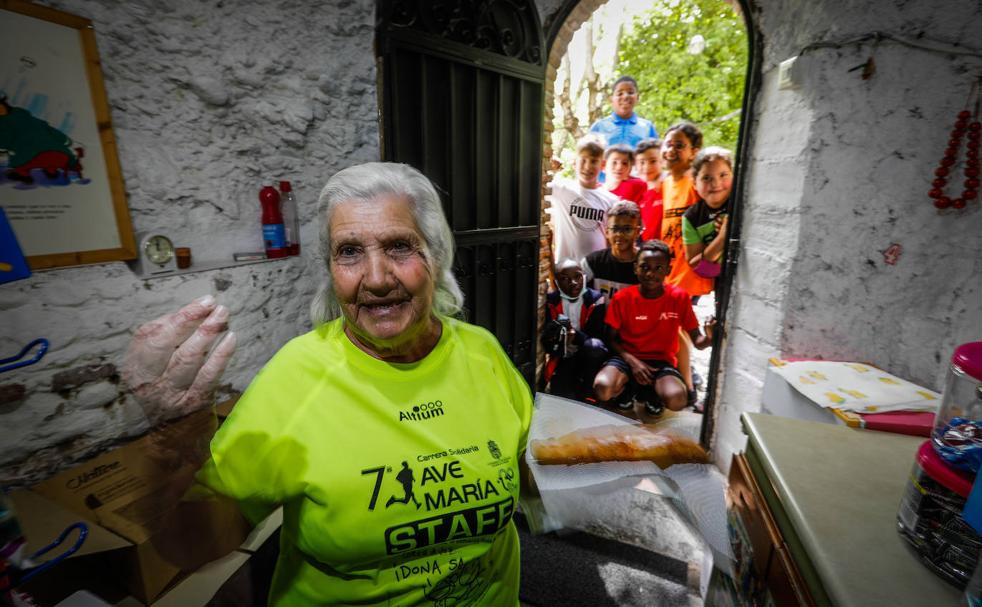 La Mari, con su equipación deportiva del Ave María, dentro de su cueva, con los niños en la puerta. 
