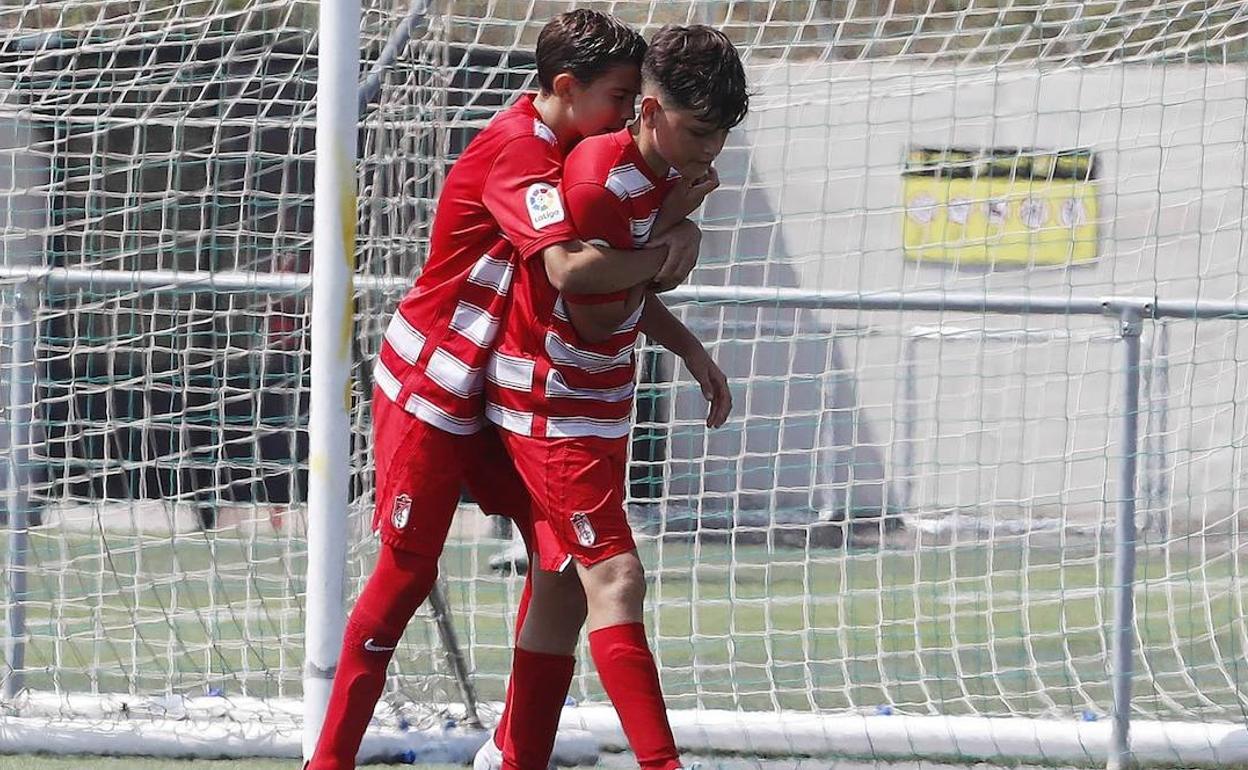 Dos jugadores del Granada se abrazan tras anotar un gol. 