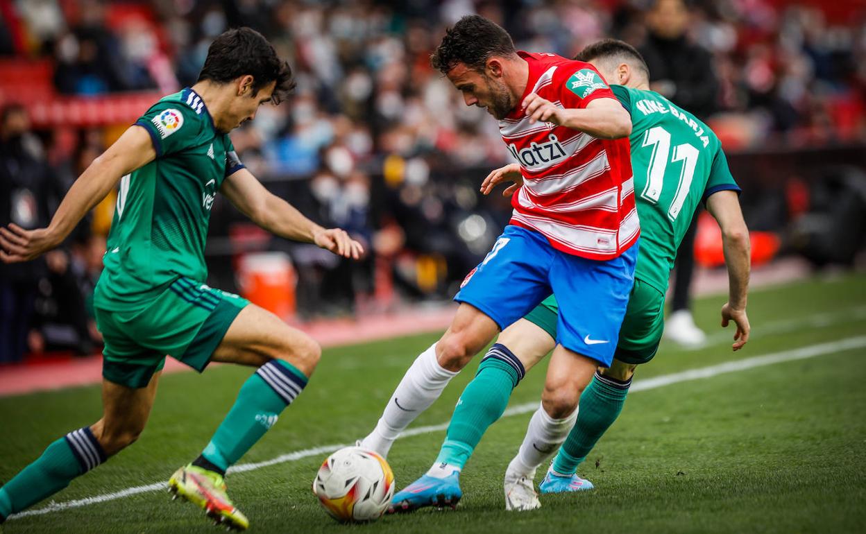 Quini se marcha de dos jugadores de Osasuna. 