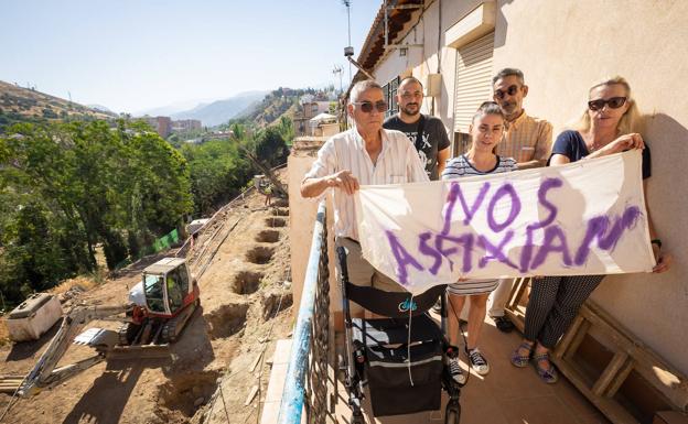 Algunos vecinos posan con una pancarta en la que denuncian que están «asfixiados». 