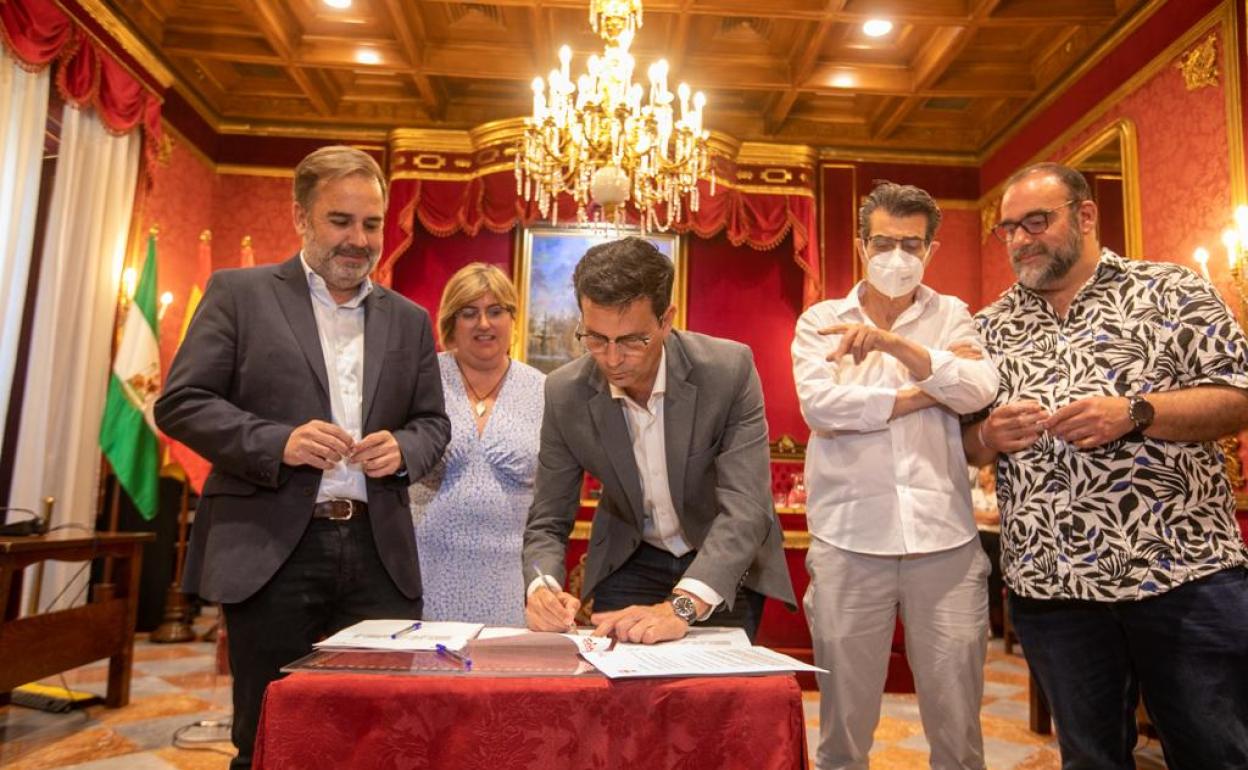 El alcalde firma el acuerdo.