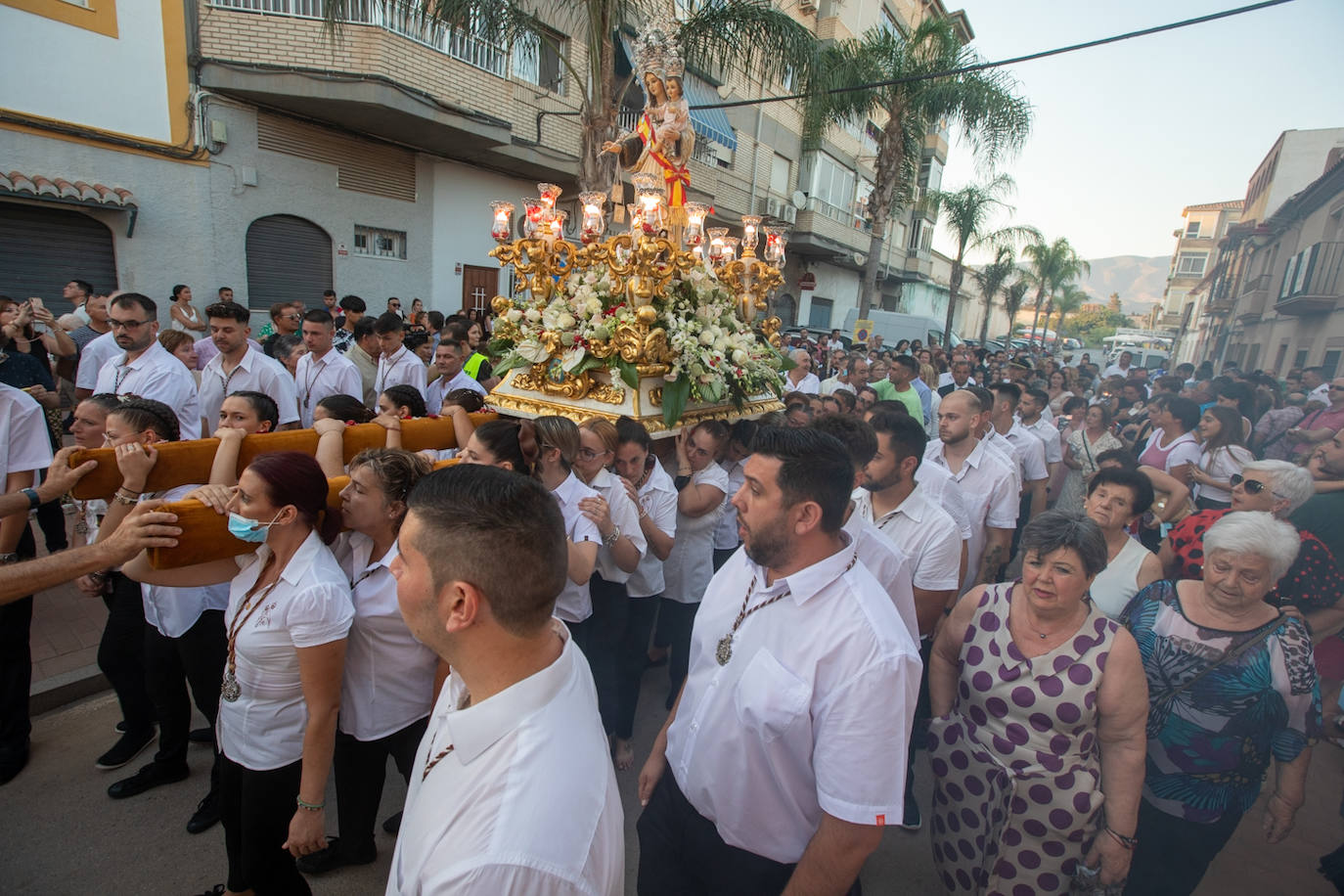 El trono de la Virgen del Carmen recibe una petalá a su paso por una de las calles de Varadero en Motril.