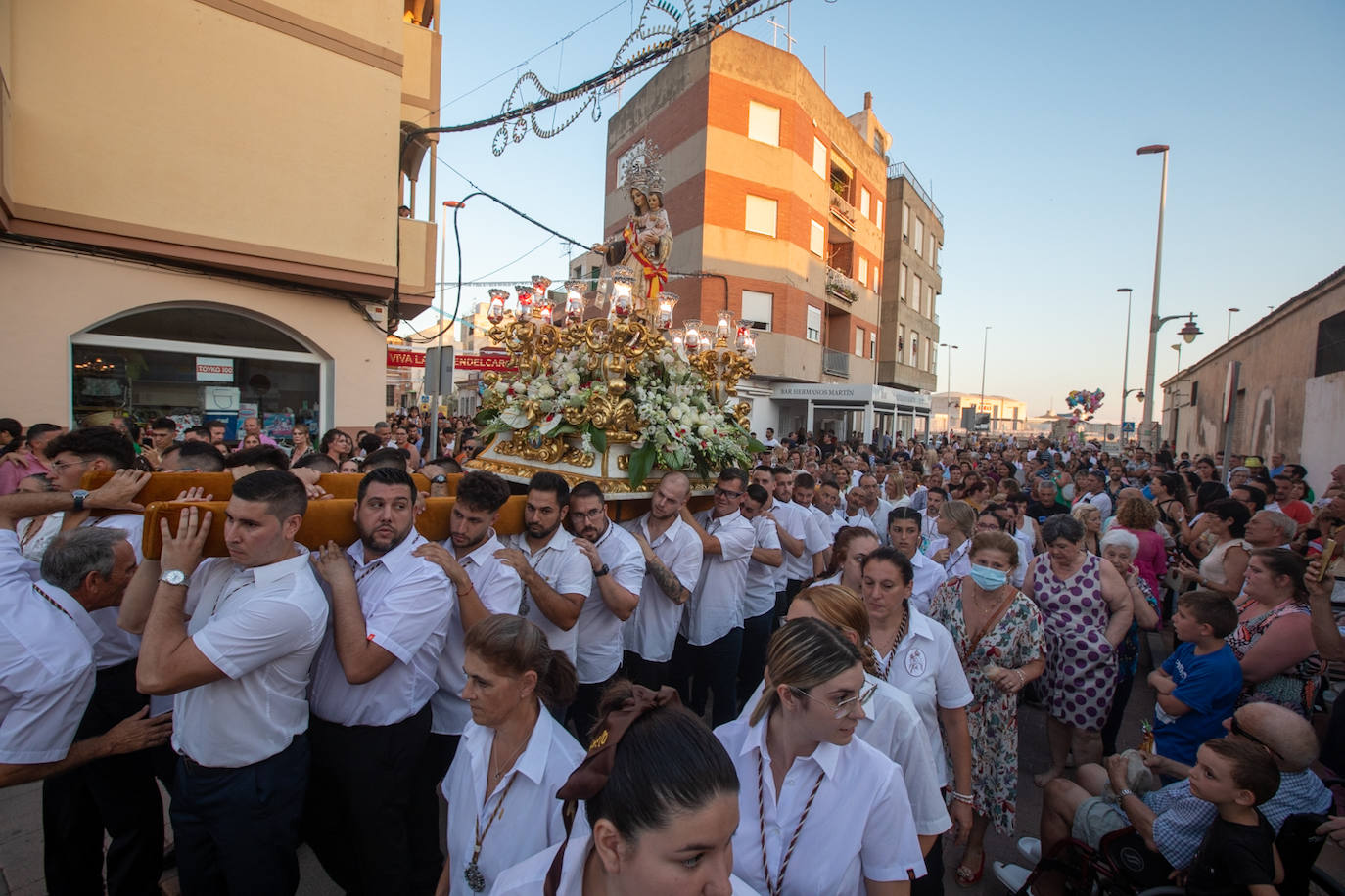 El trono de la Virgen del Carmen recibe una petalá a su paso por una de las calles de Varadero en Motril.