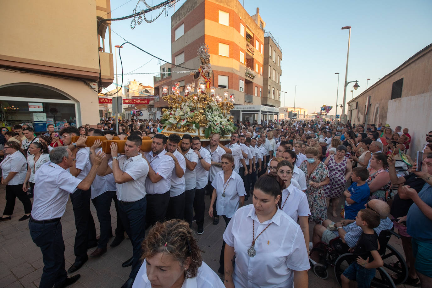 El trono de la Virgen del Carmen recibe una petalá a su paso por una de las calles de Varadero en Motril.