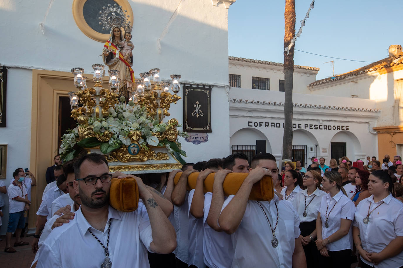 El trono de la Virgen del Carmen recibe una petalá a su paso por una de las calles de Varadero en Motril.