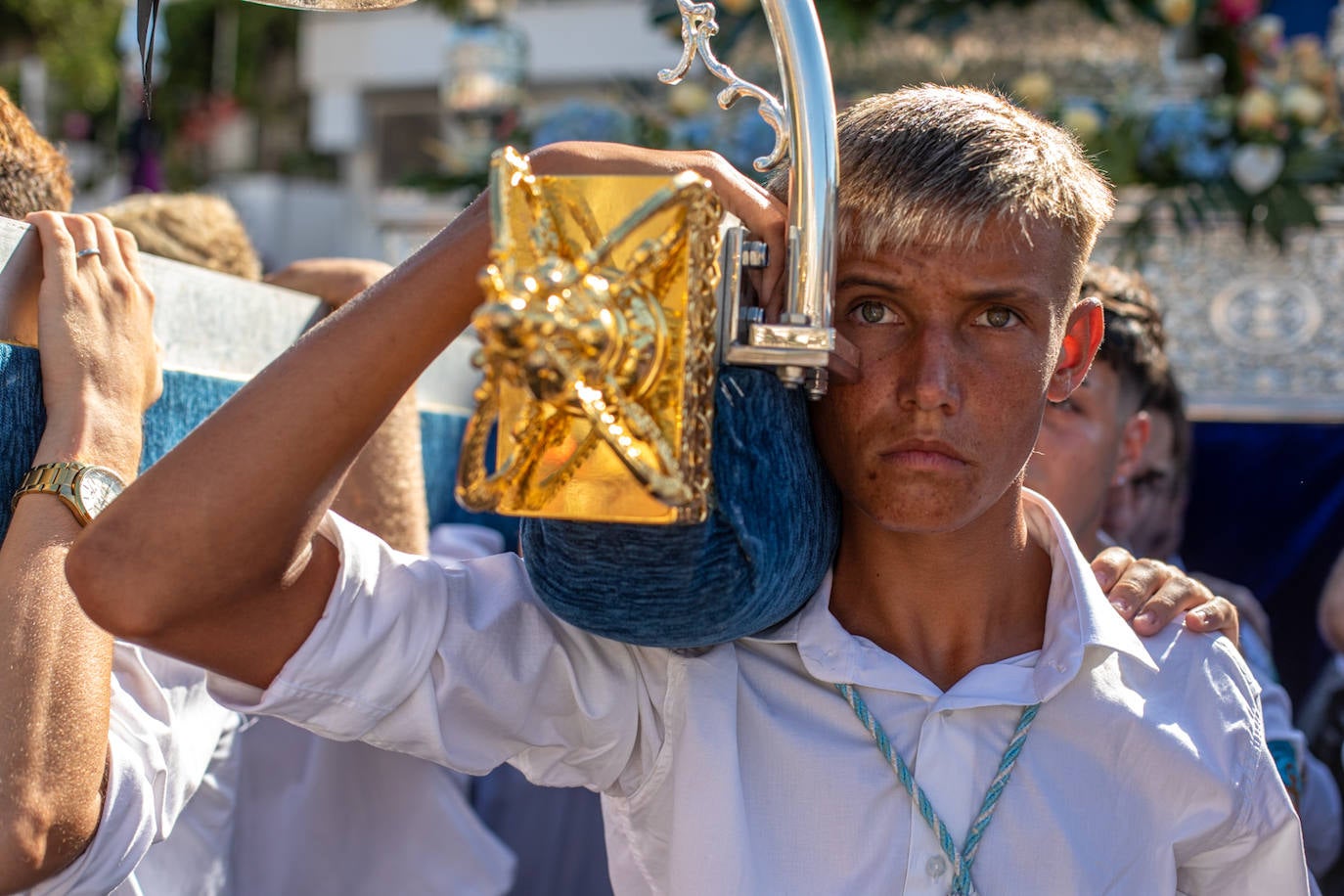 La Virgen del Carmen de Almuñéca, con el Barrio de Los Marinos al fondo, enfila la playa de San Cristóbal tras salir de la capilla.