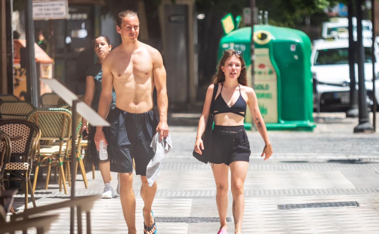 Sin camiseta por el centro de Granada. 