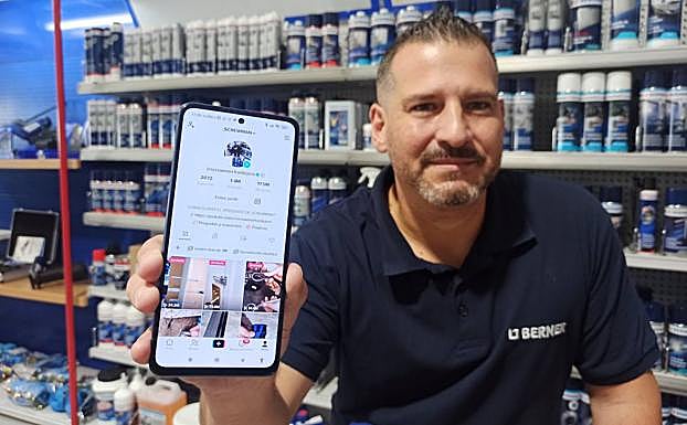 Fran Tejera con su teléfono móvil en Berner, tienda en la que trabaja.