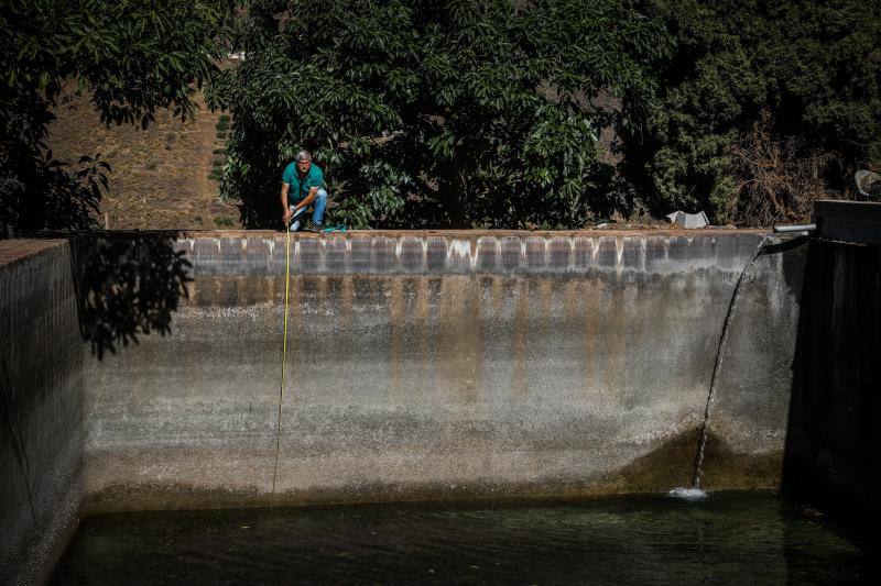 El presidente de la comunidad de regantes de Río Verde, Manuel Novo, midiendo la balsa de agua de riego en una de las fincas afectadas por la sequía. 