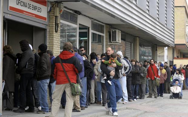 Desempleados hacen cola en una oficina de empleo. 