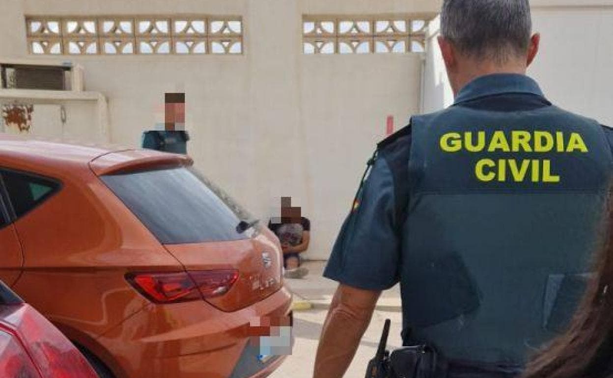 Al fondo, sentado, el conductor que fue interceptado por la Guardia Civil. A la izquierda, el coche sustraído.