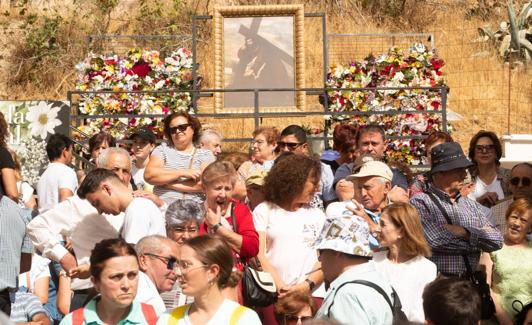 Una imagen del Cristo del Paño rodeada de flores junto a la iglesia de la Encarnación de Moclín.