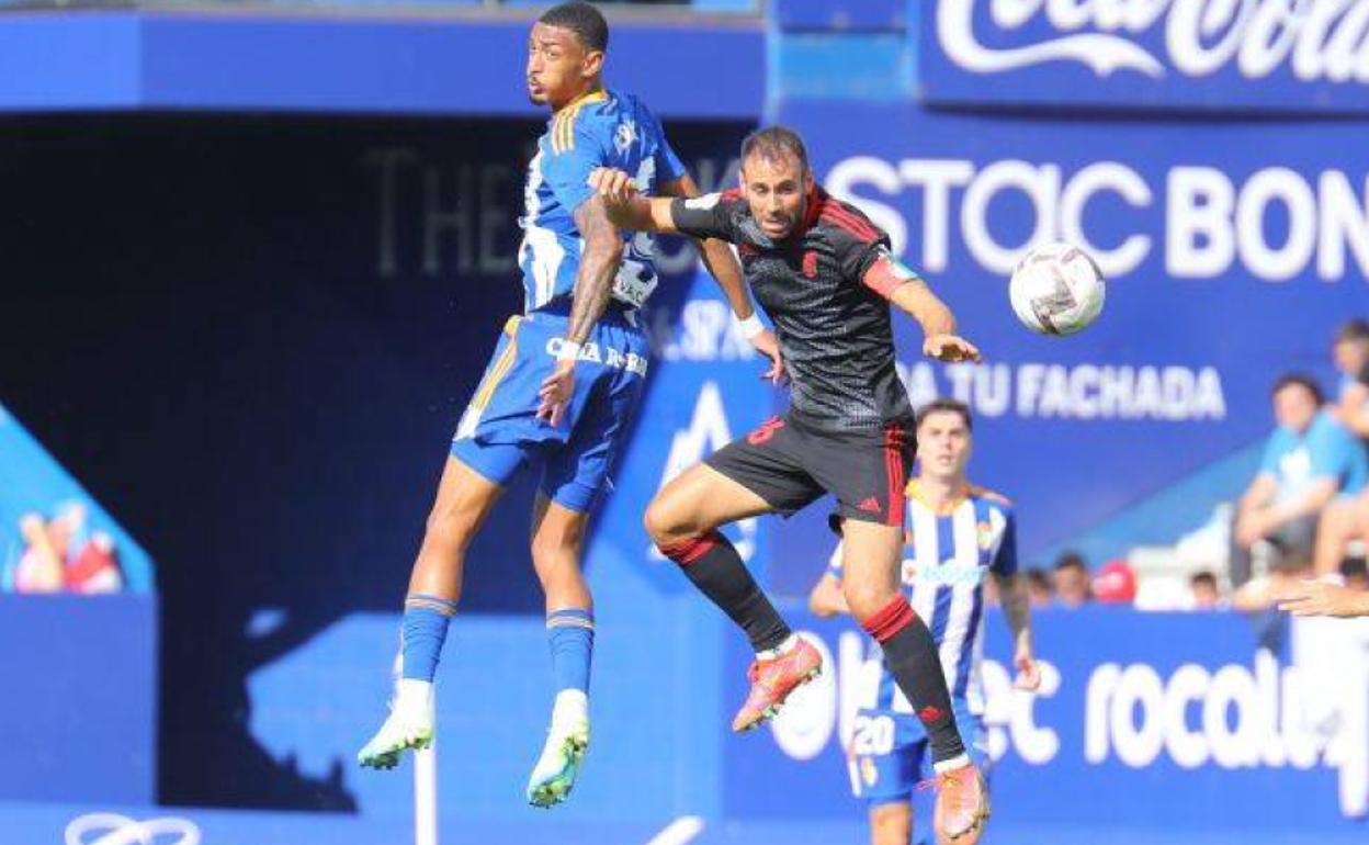 Víctor Díaz salta a por un balón con Derik. 