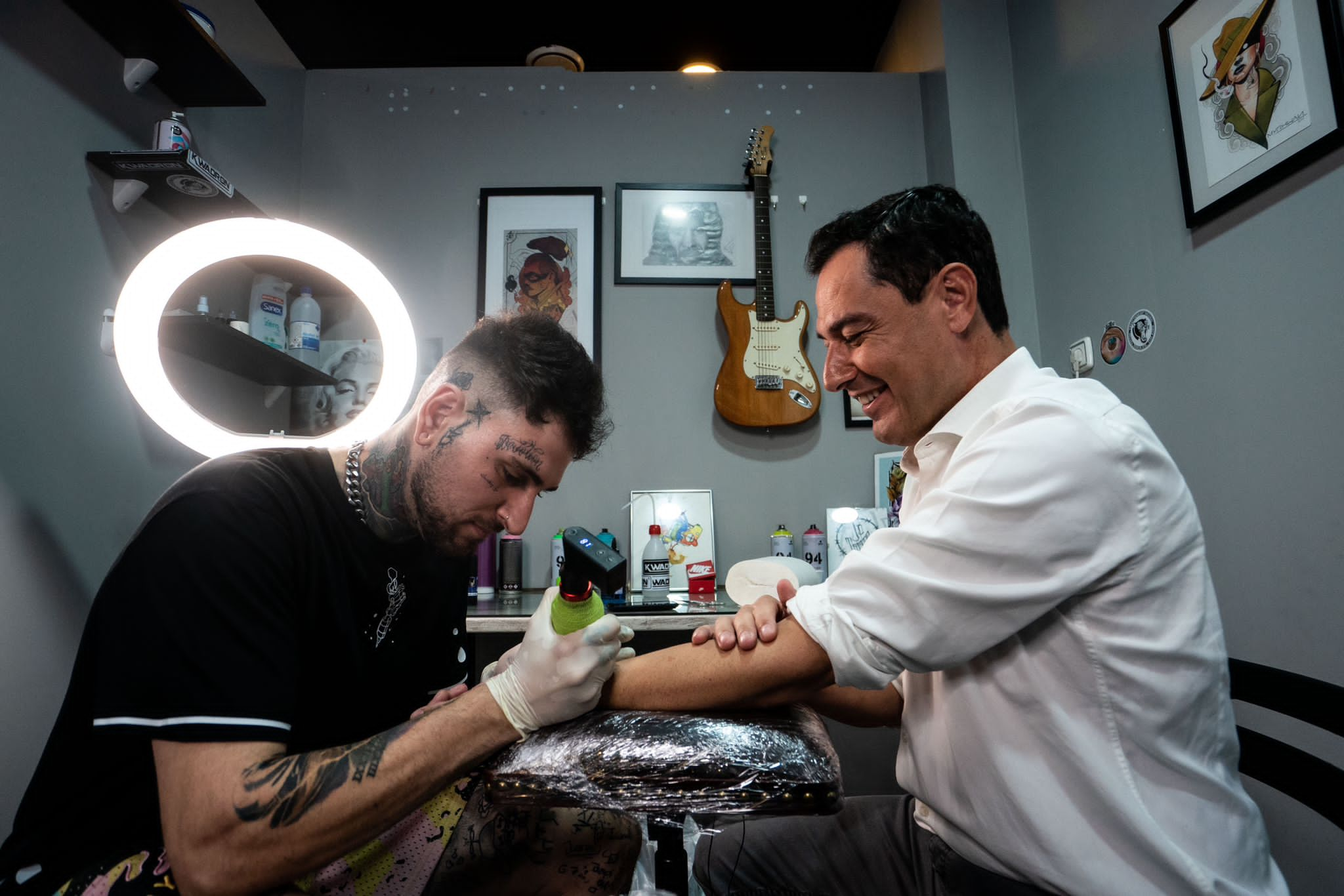 Javier Pascual tatúa en el brazo de Juanma Moreno el resultado electoral en escaños de las pasadas elecciones andaluzas.